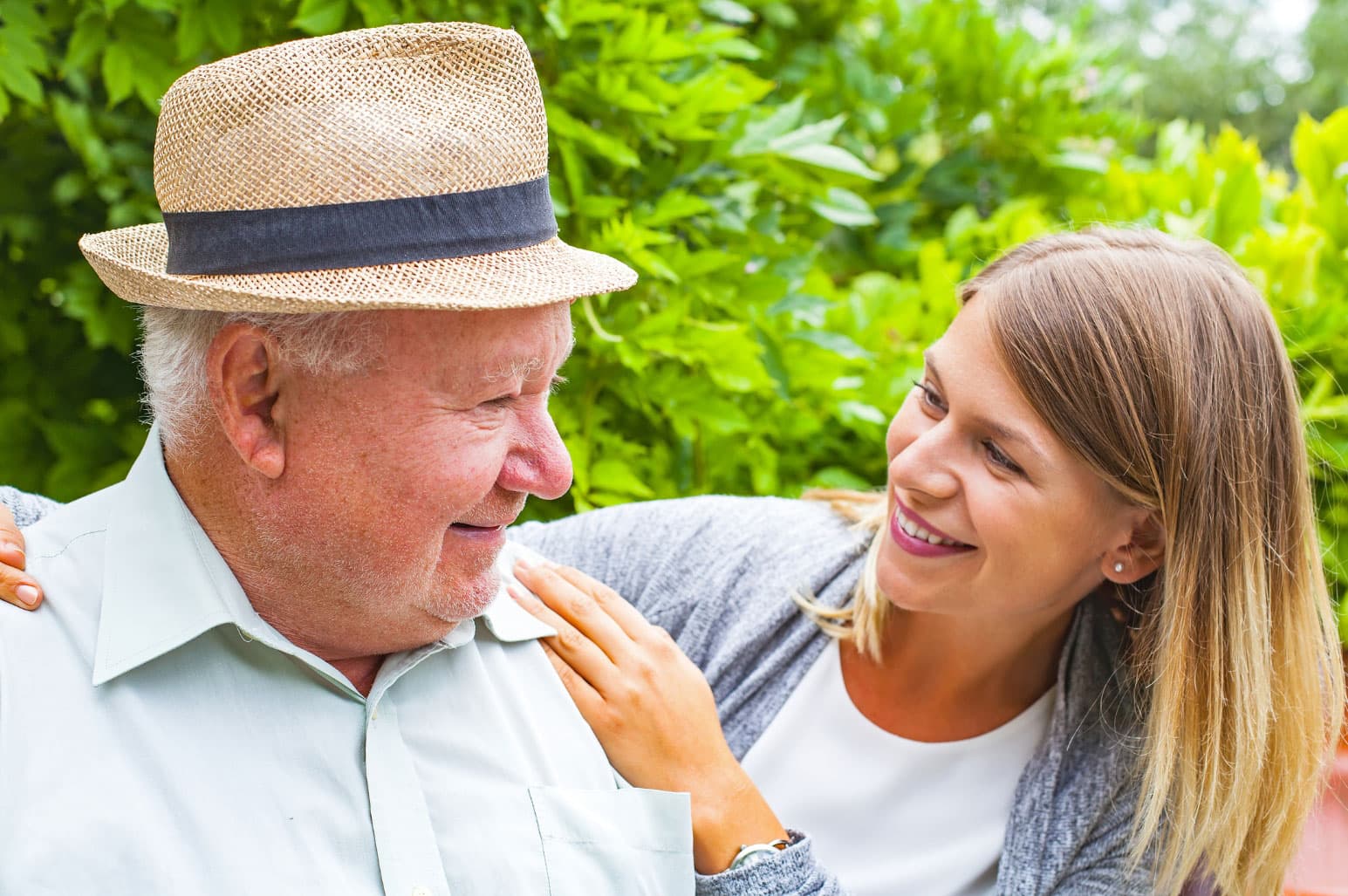 younger female with her arms around senior adult male