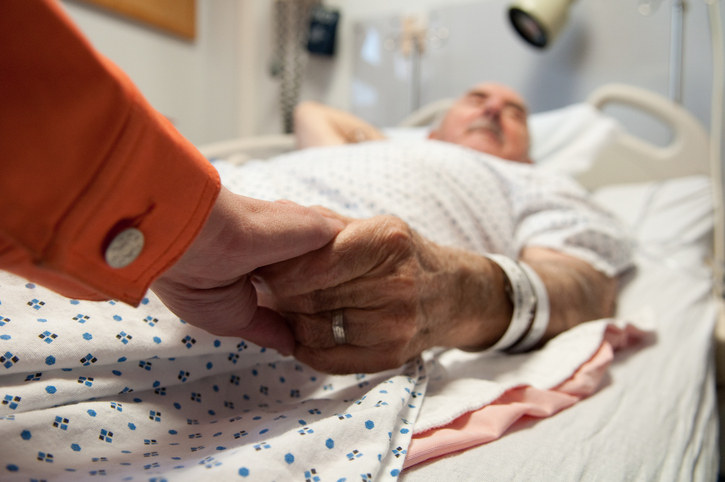 senior adult in emergency room, holding caregiver's hand, how assisted living helps prevent emergency room visits