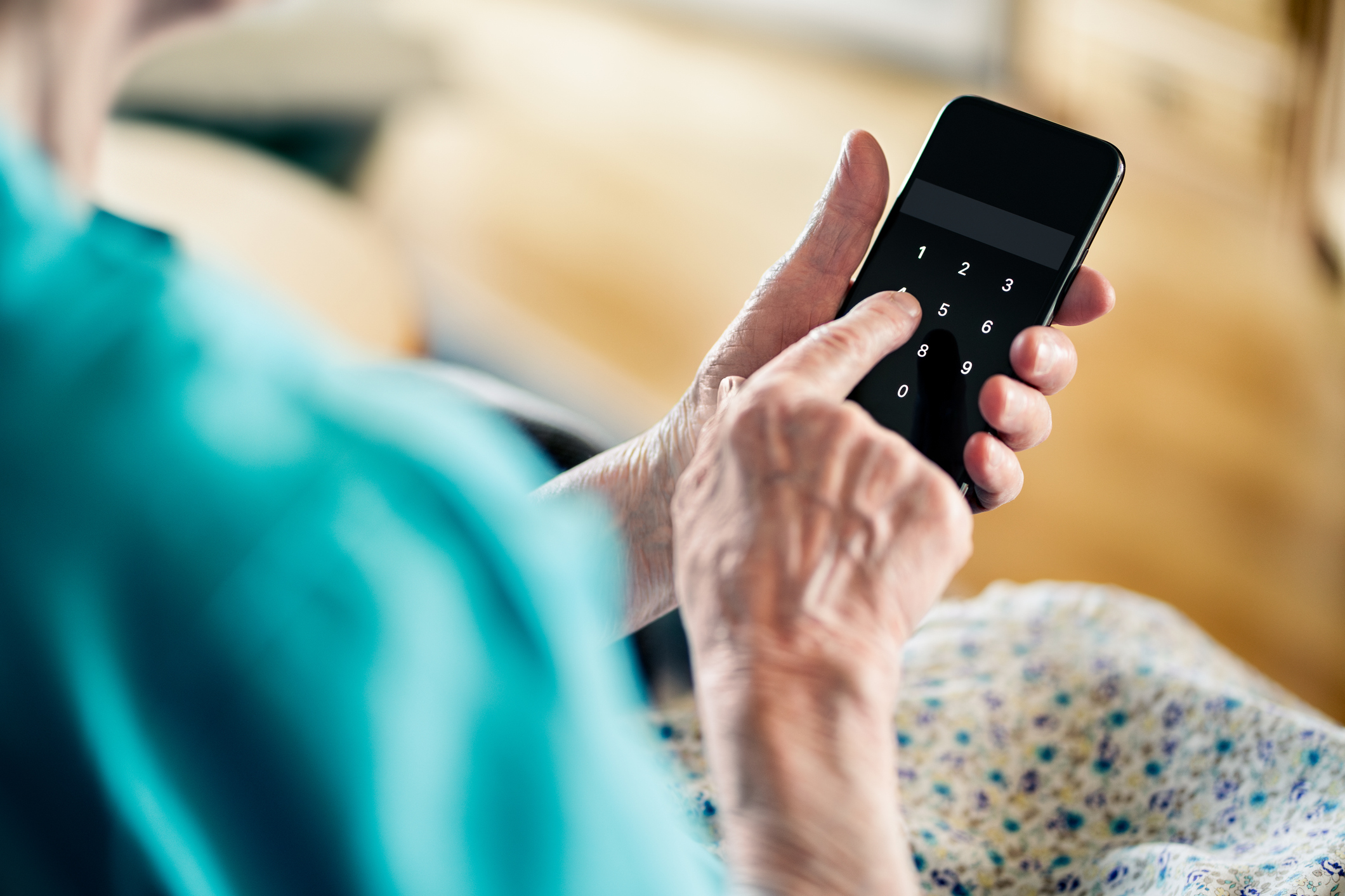 Older adult woman holding a phone typing password number code.