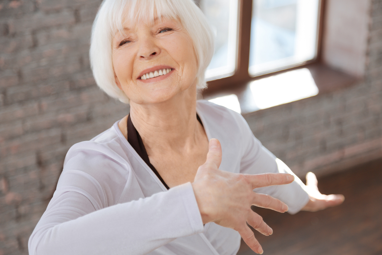Smiling senior woman enjoying light exercise, embodying confidence and joy while aging gracefully