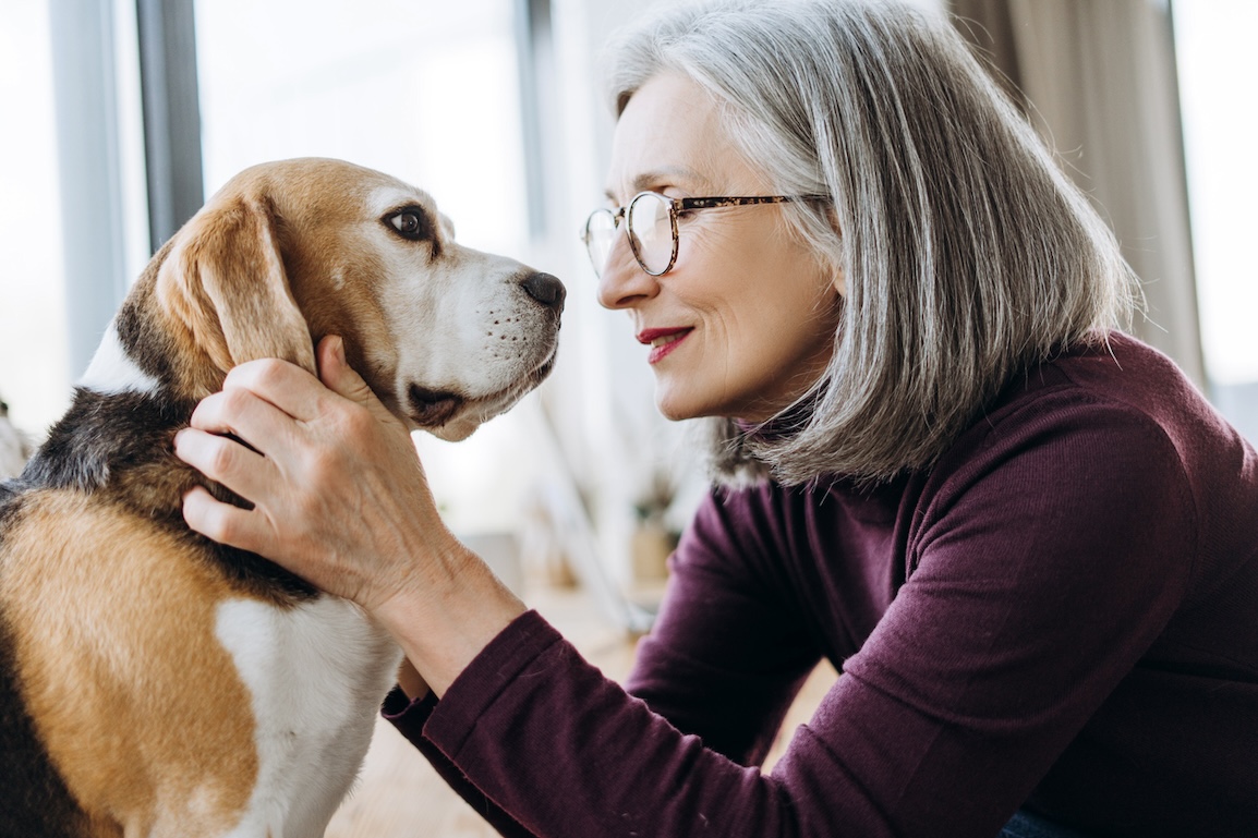 Mature woman hugging her dog.
