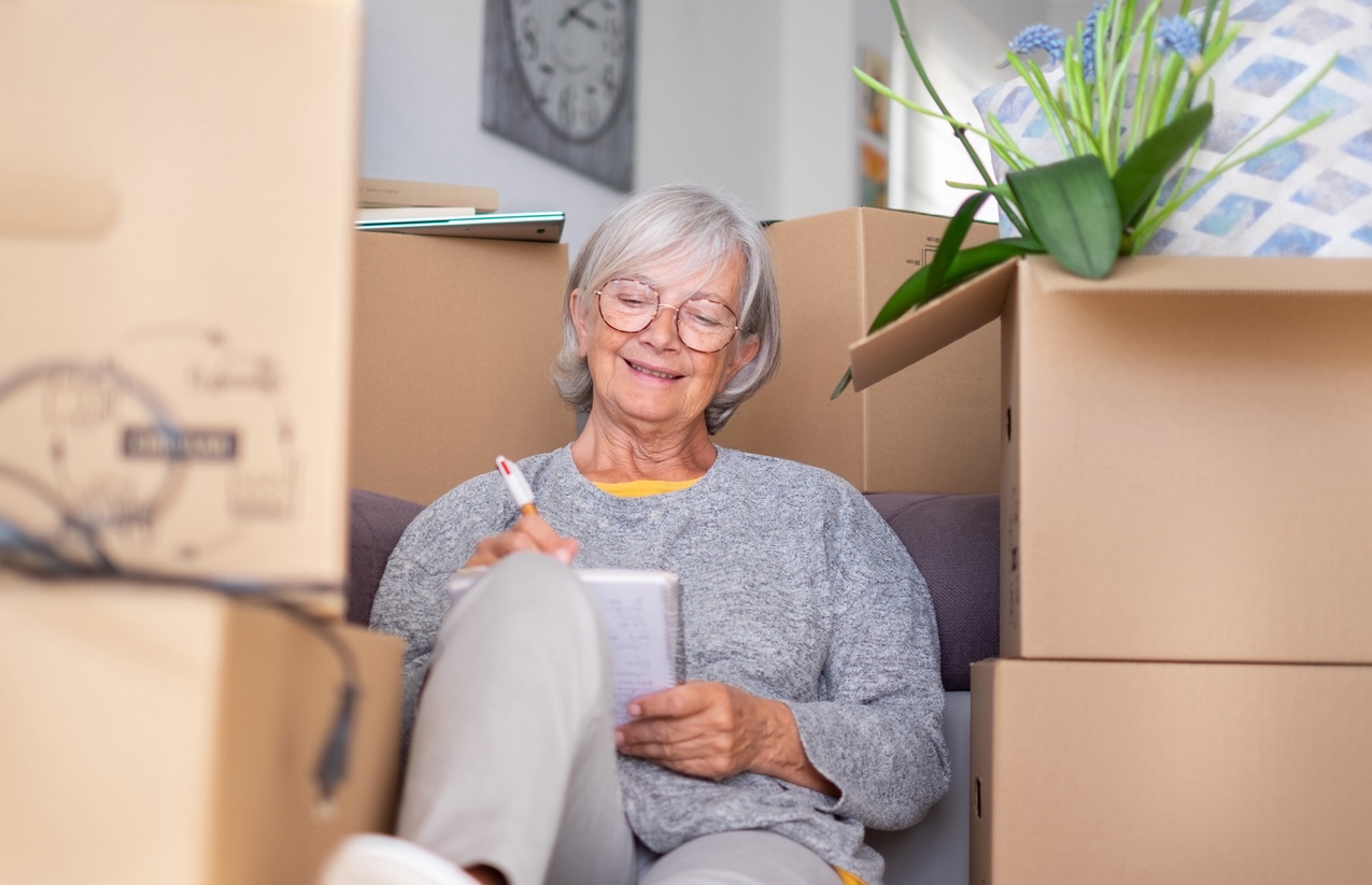 Senior woman organizing boxes and preparing for a move to senior living