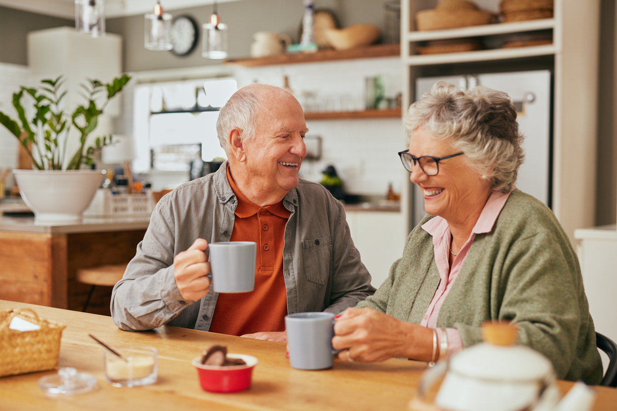 Senior couple enjoying coffee and conversation in a comfortable home setting