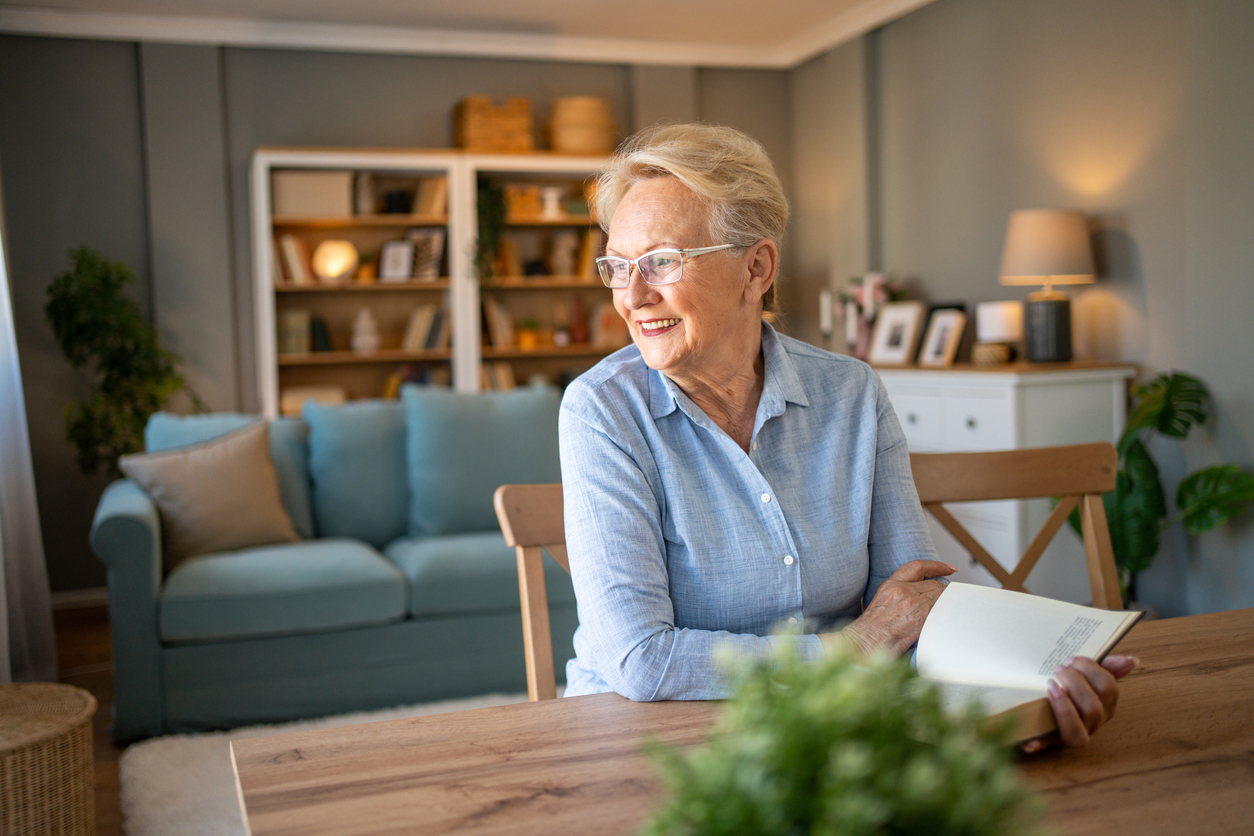 Senior woman relaxing with a book in a comfortable apartment